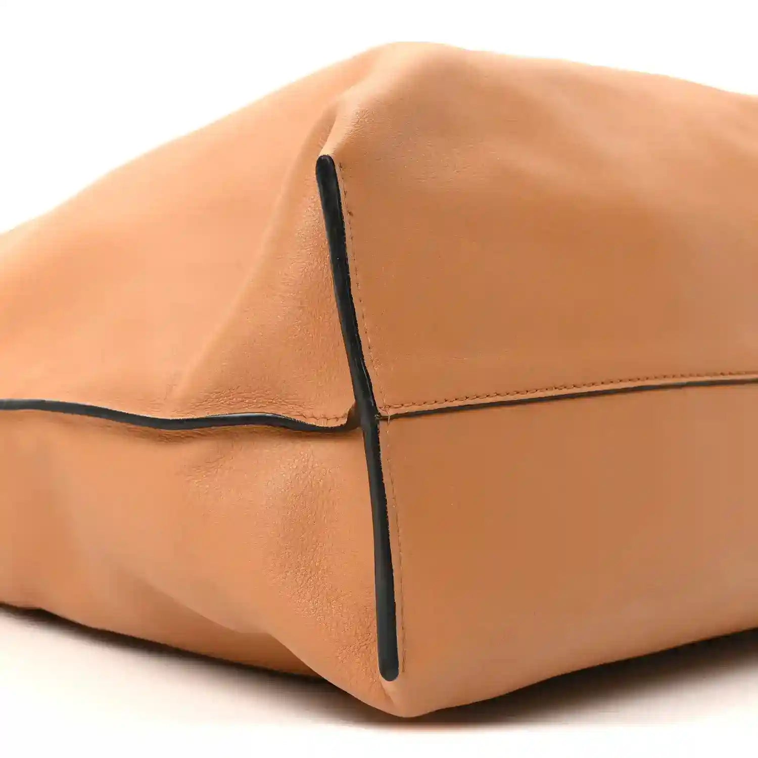 Loewe Flamenco knot bag corner close-up, warm tan leather with dark edge trim.