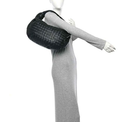 Black woven leather shoulder bag handle and woven top edge