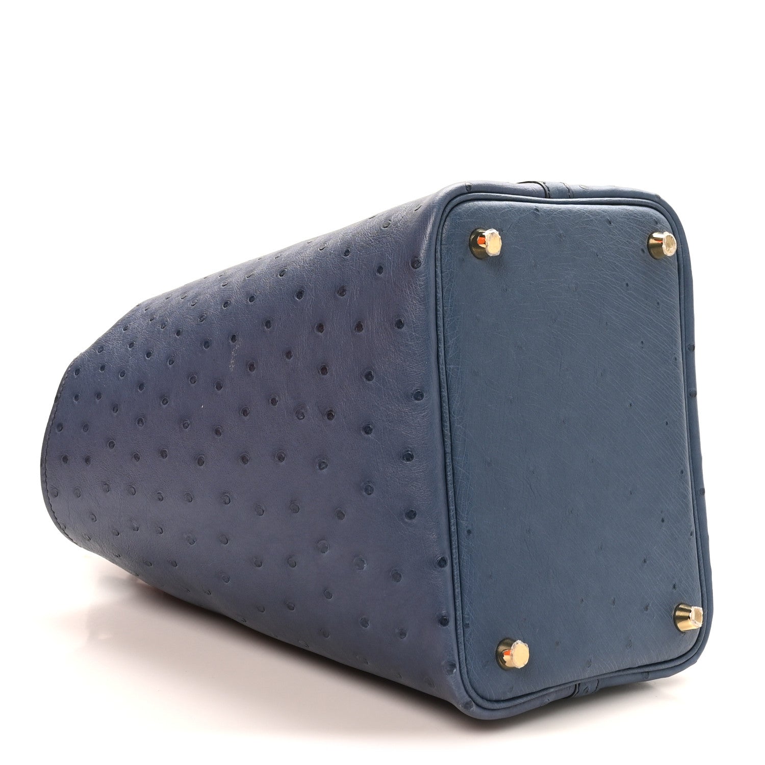 Blue ostrich leather bucket bag with gold corner hardware and turn-lock closure.