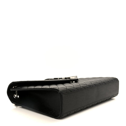 Black quilted satchel with rounded corners and stitched top handle