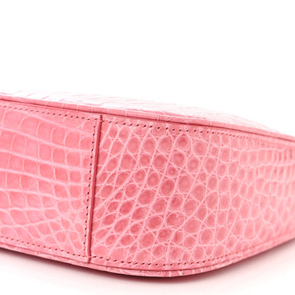 Pink alligator-textured hobo bag corner with stitched edging and side panel detail