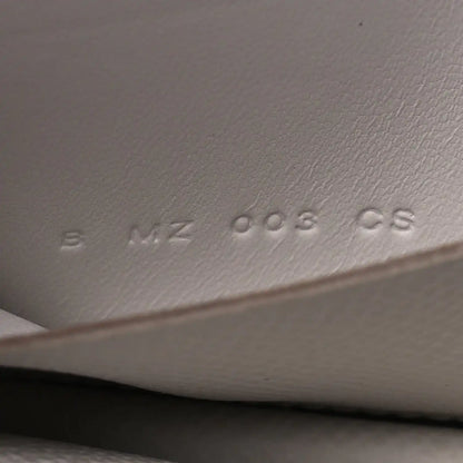 Embossed serial/markings on pale gray leather interior surface