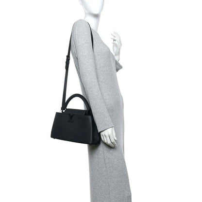 Matte black leather handbag with crossbody strap and top handle