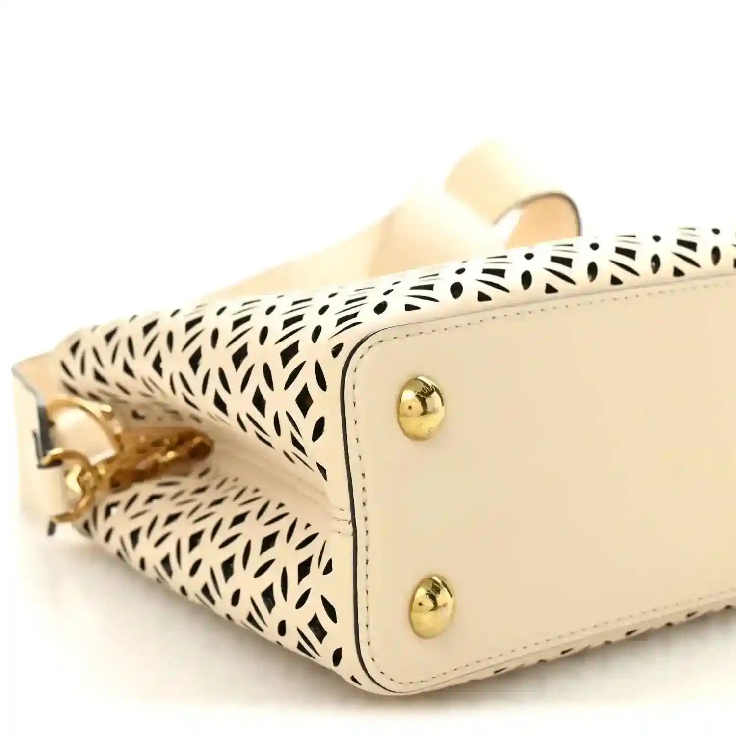 Louis Vuitton mini handbag corner view with gold hardware and cut-out lattice body
