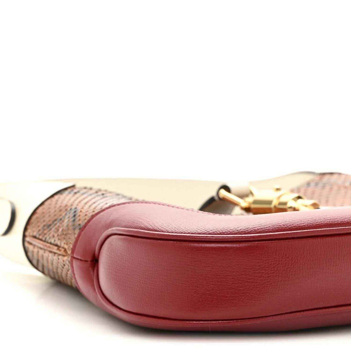 Hobo bag side view with pink leather trim, snakeskin panel, and gold clasp.