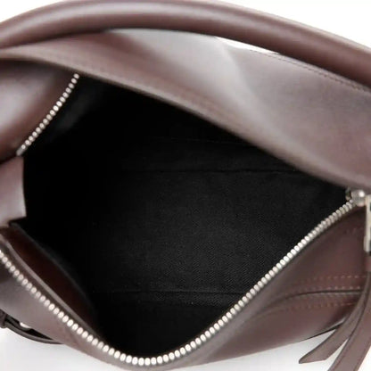 Leather interior of small biker bag with zipper trim and stitched panel details