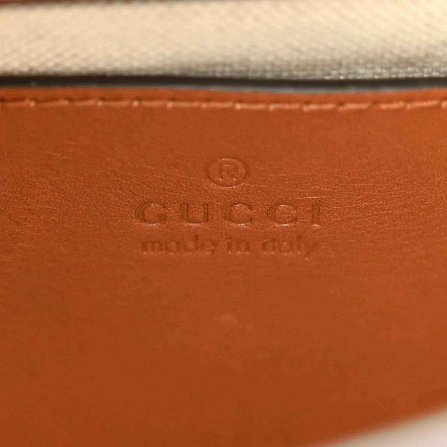 Gucci mini tote bag leather base with embossed "GUCCI" stamp.