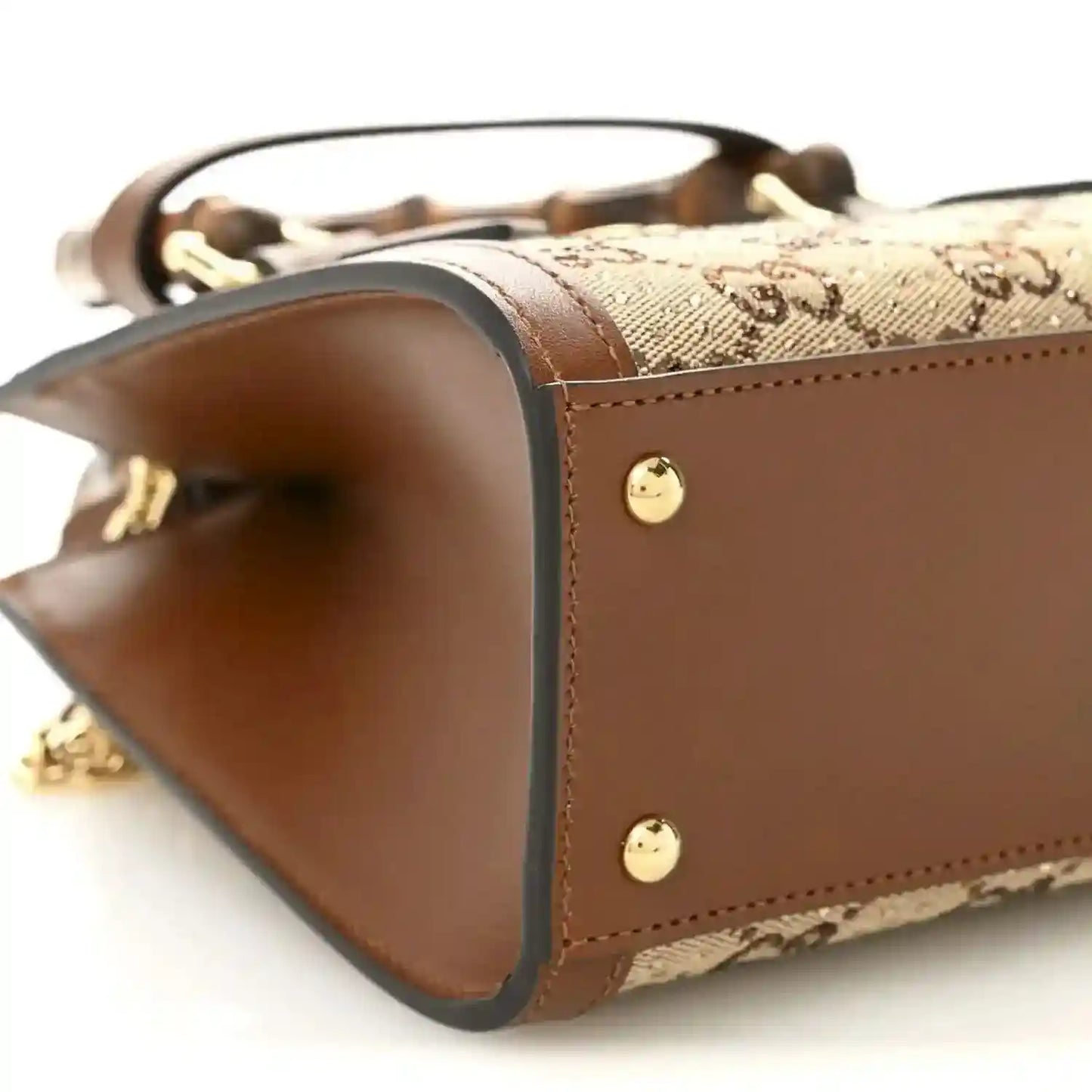 Mini tote bag corner view with brown leather trim and two gold-tone snap studs