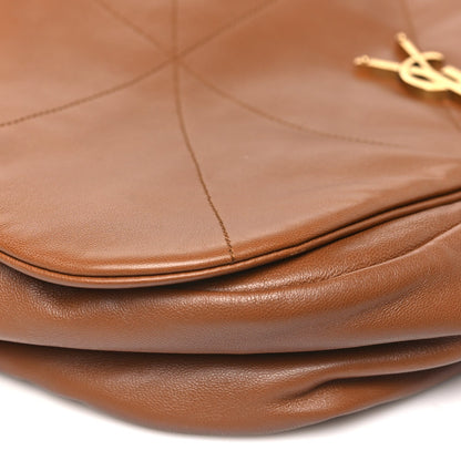 Curved leather top edge and matte gold monogram on quilted bag front