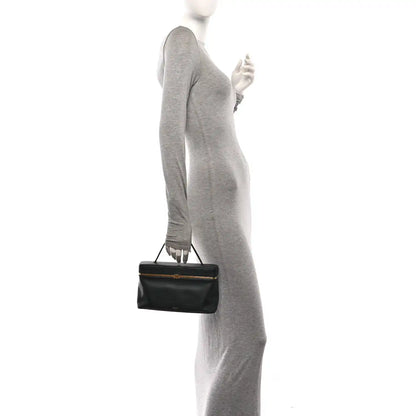 Celine black rectangle bag worn by model, with top handle and gold-tone clasp