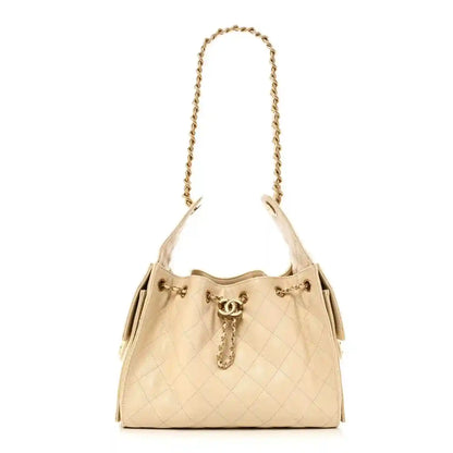 Quilted small handbag in light beige leather with top chain handle and drawstring-like closure