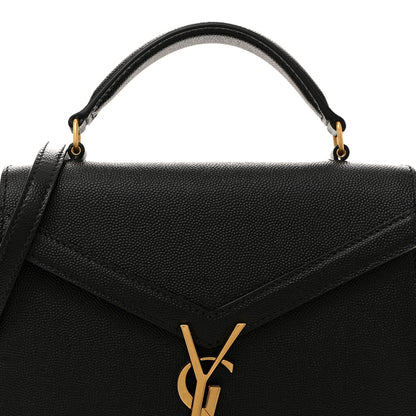 Black leather top handle bag with gold ring hardware and V-shaped flap detail.
