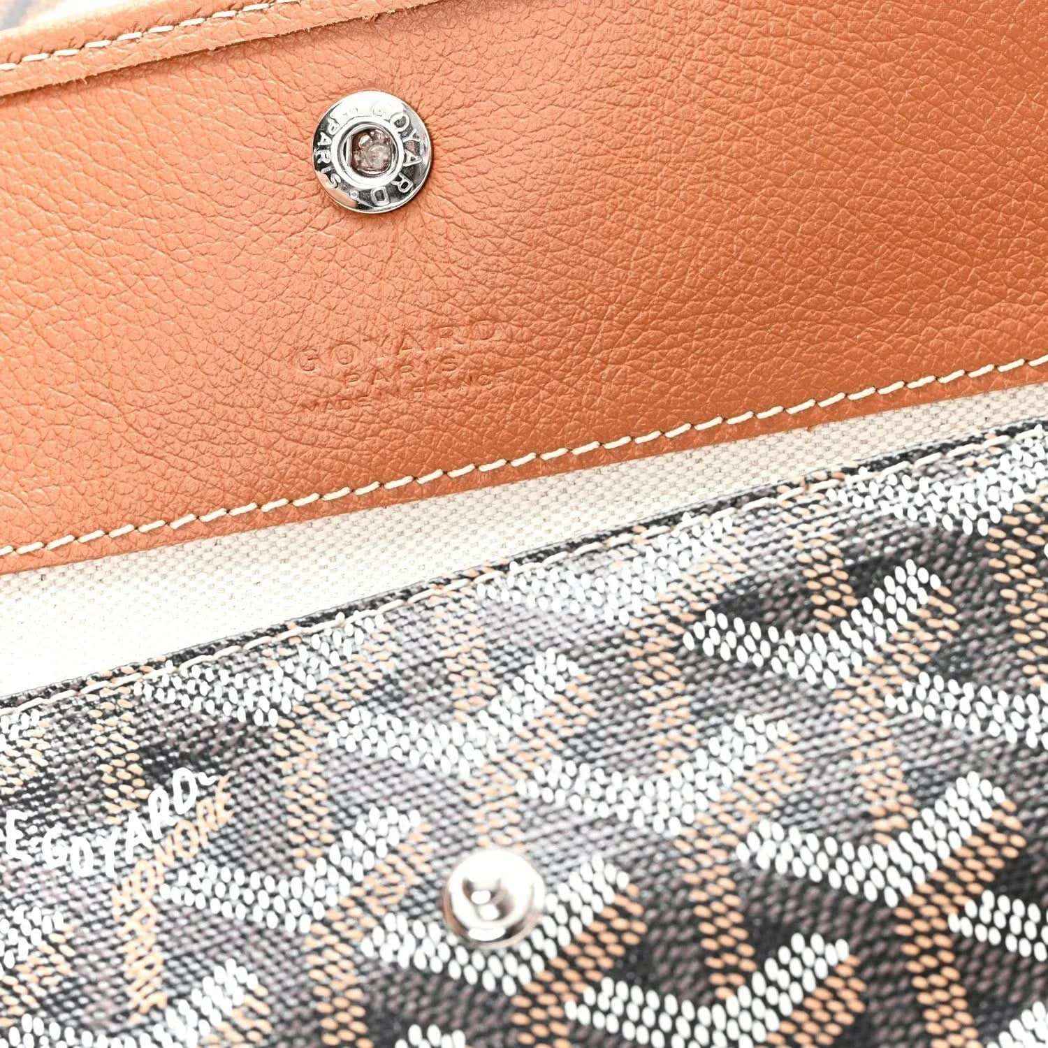 Tan leather pocket detail with metal snap and visible stitching