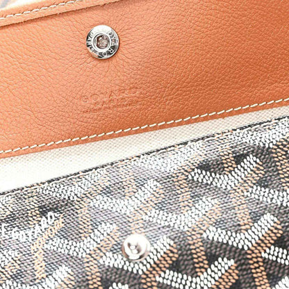 Tan leather pocket detail with metal snap and visible stitching