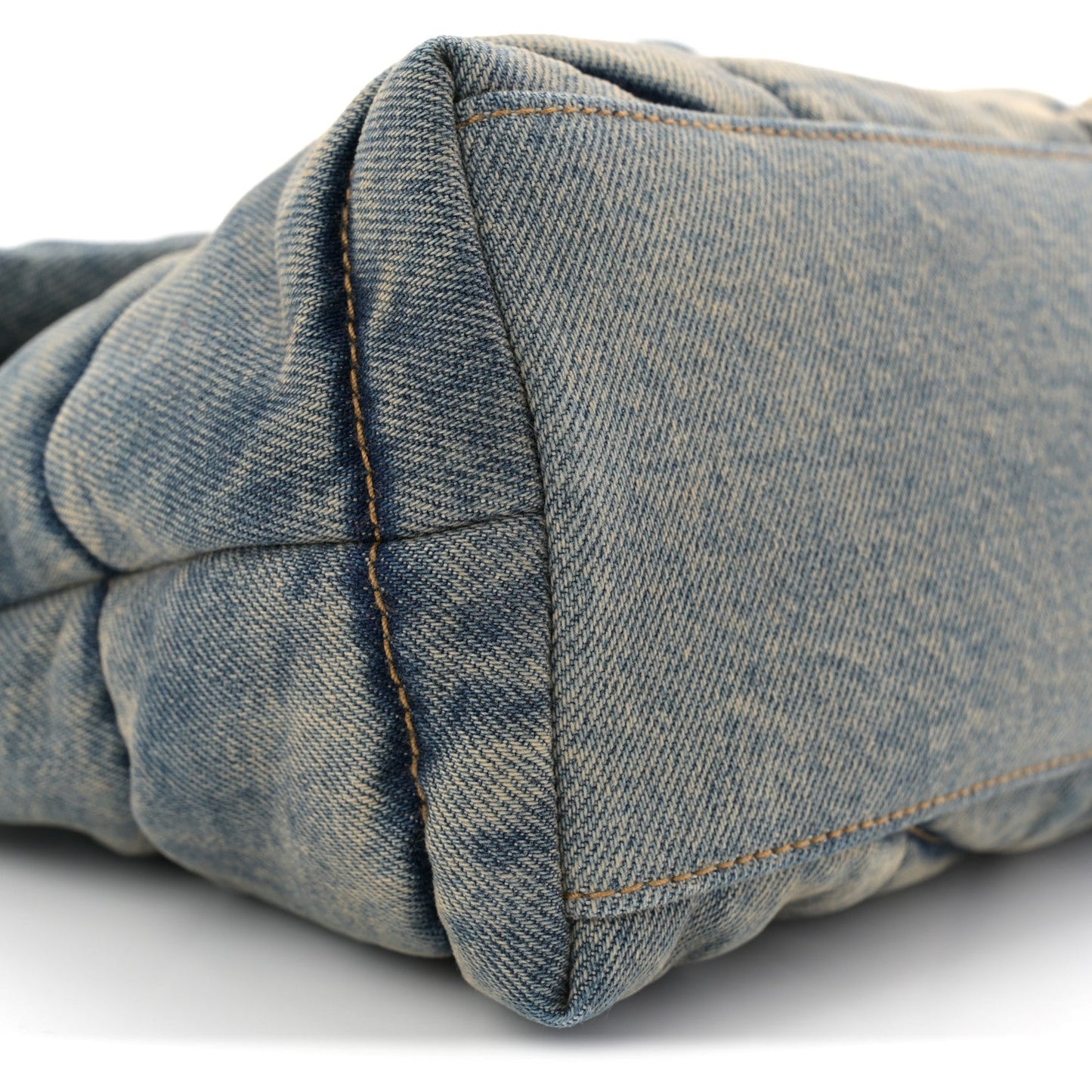 Denim quilted puffer satchel side seam detail with tan stitching