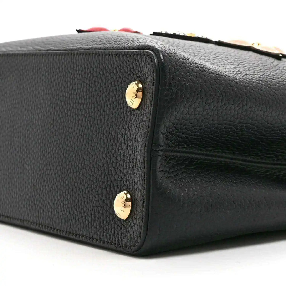 Black Louis Vuitton handbag side with gold stud accents and pebbled leather finish