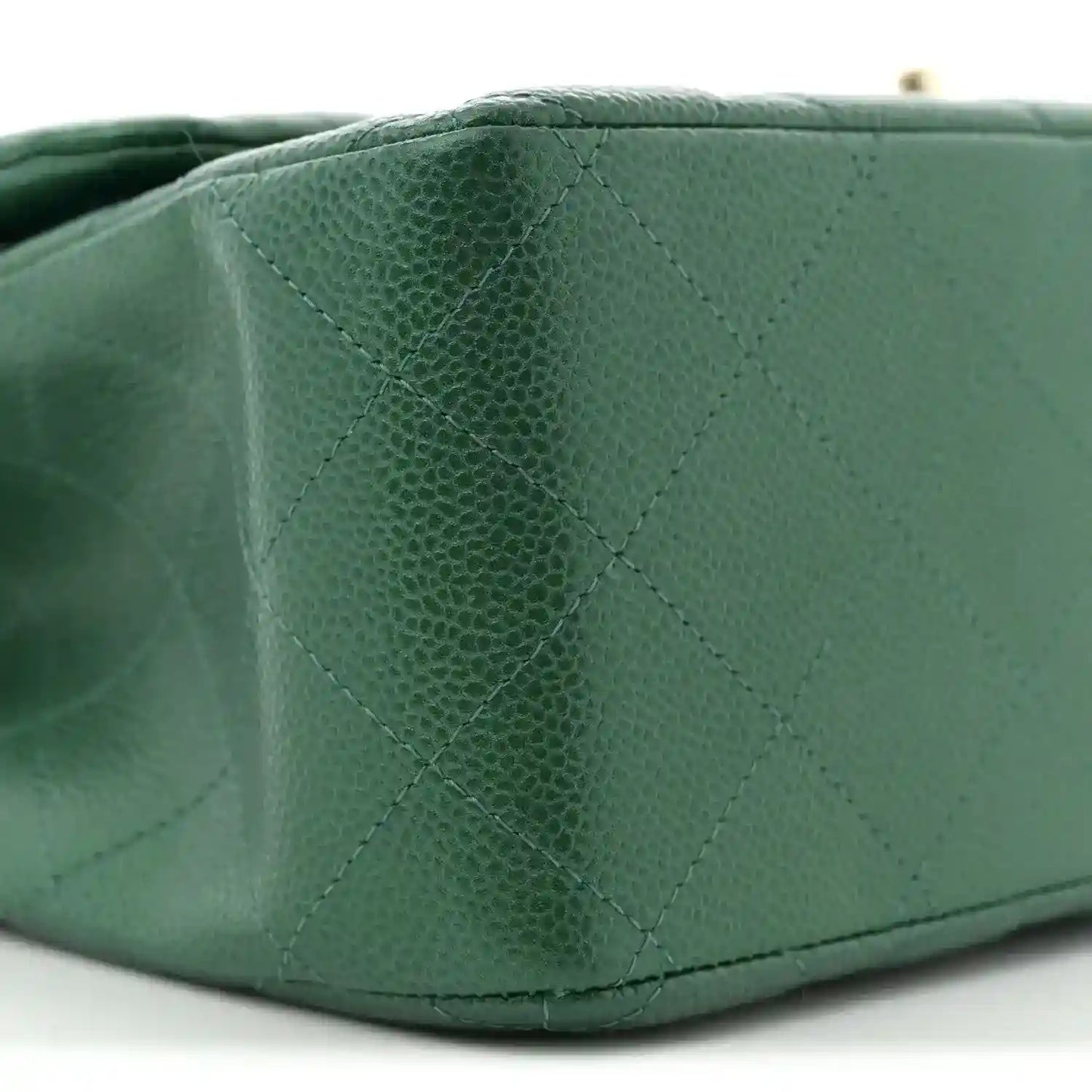 Green quilted caviar leather bag corner with stitched diamond pattern detail.