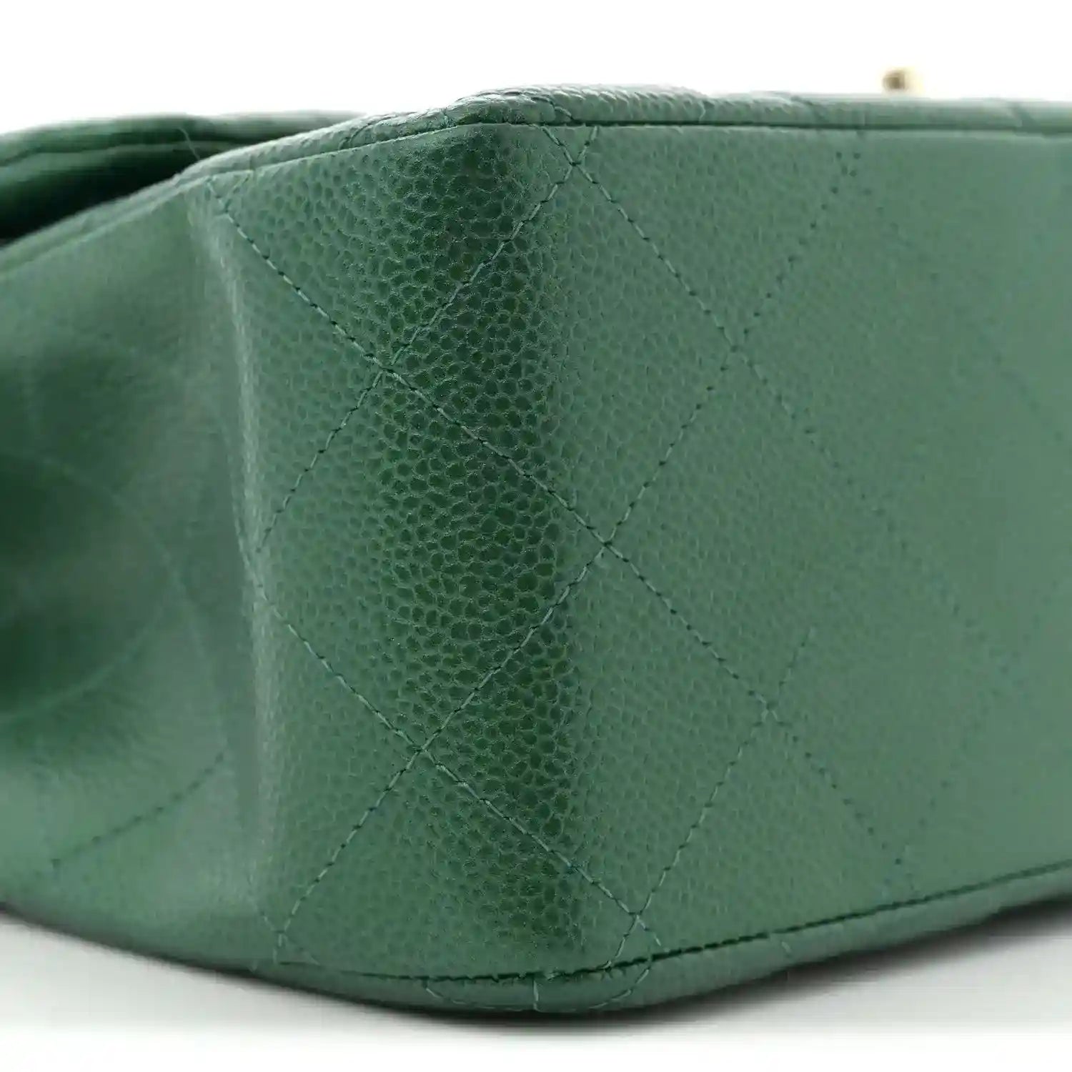 Green quilted caviar leather bag corner with stitched diamond pattern detail.