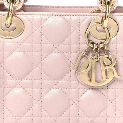 Mini Lady Dior handbag close-up: rose pink diamond Cannage quilting and gold hardware charms