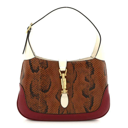 Small hobo bag with brown snakeskin front, burgundy leather base, and cream handles.
