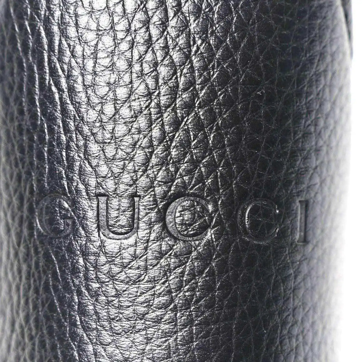 Black grained calfskin with embossed Gucci logo stamp