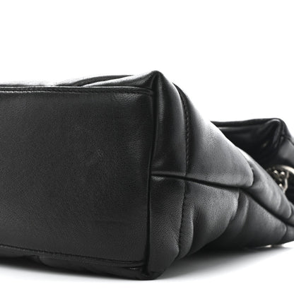 Black quilted lambskin puffer small satchel with flap seam and compact rectangular shape.