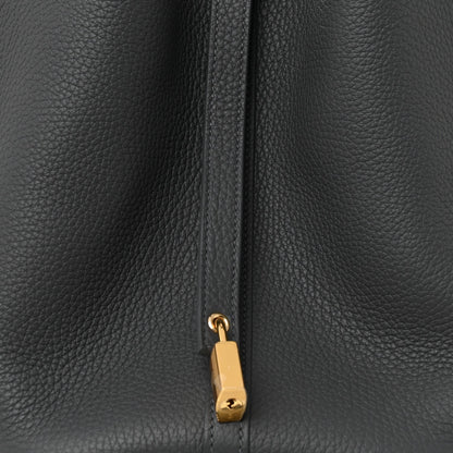 Close-up of dark gray leather zipper pull with gold-toned lock charm