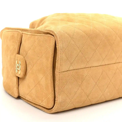 Chanel quilted beige suede handbag side view with front pocket flap detail