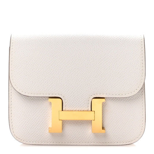 Pale gray slim leather wallet with flap and gold H clasp closure.