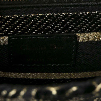 Close-up of handbag interior pocket and gold chain trim on black fabric
