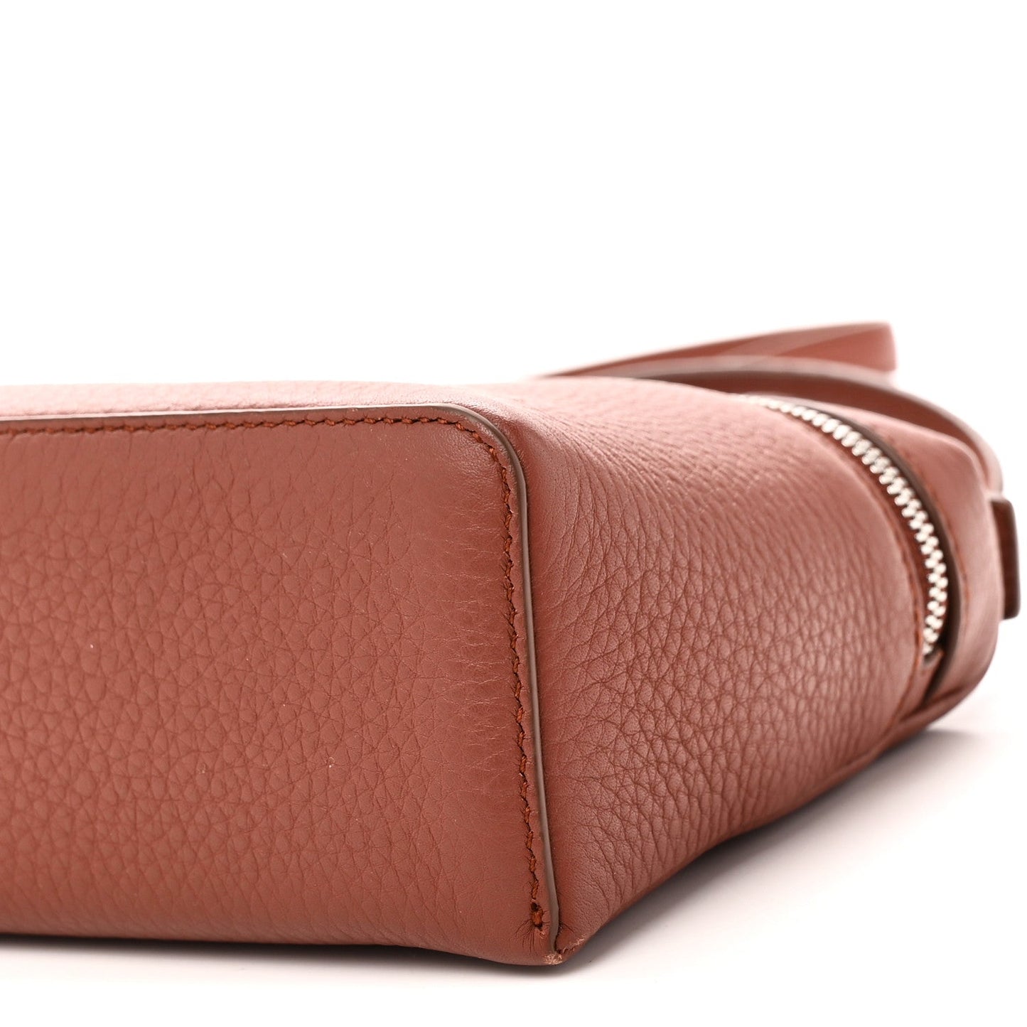 Side close-up of grained calfskin pouch with zipper edge and rounded base