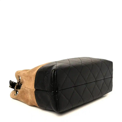 Small shopping bag with black quilted flap, beige side panel, and gold chain
