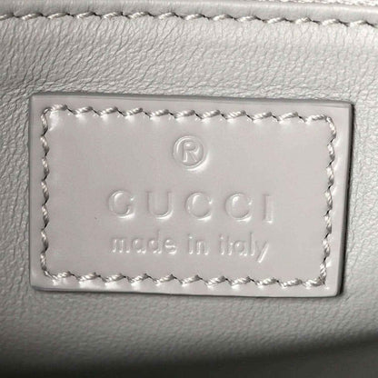 Light grey leather bag label with embossed Gucci and “Made in Italy” text