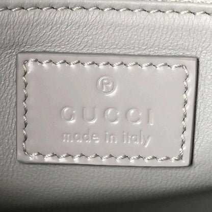 Light grey leather bag label with embossed Gucci and “Made in Italy” text