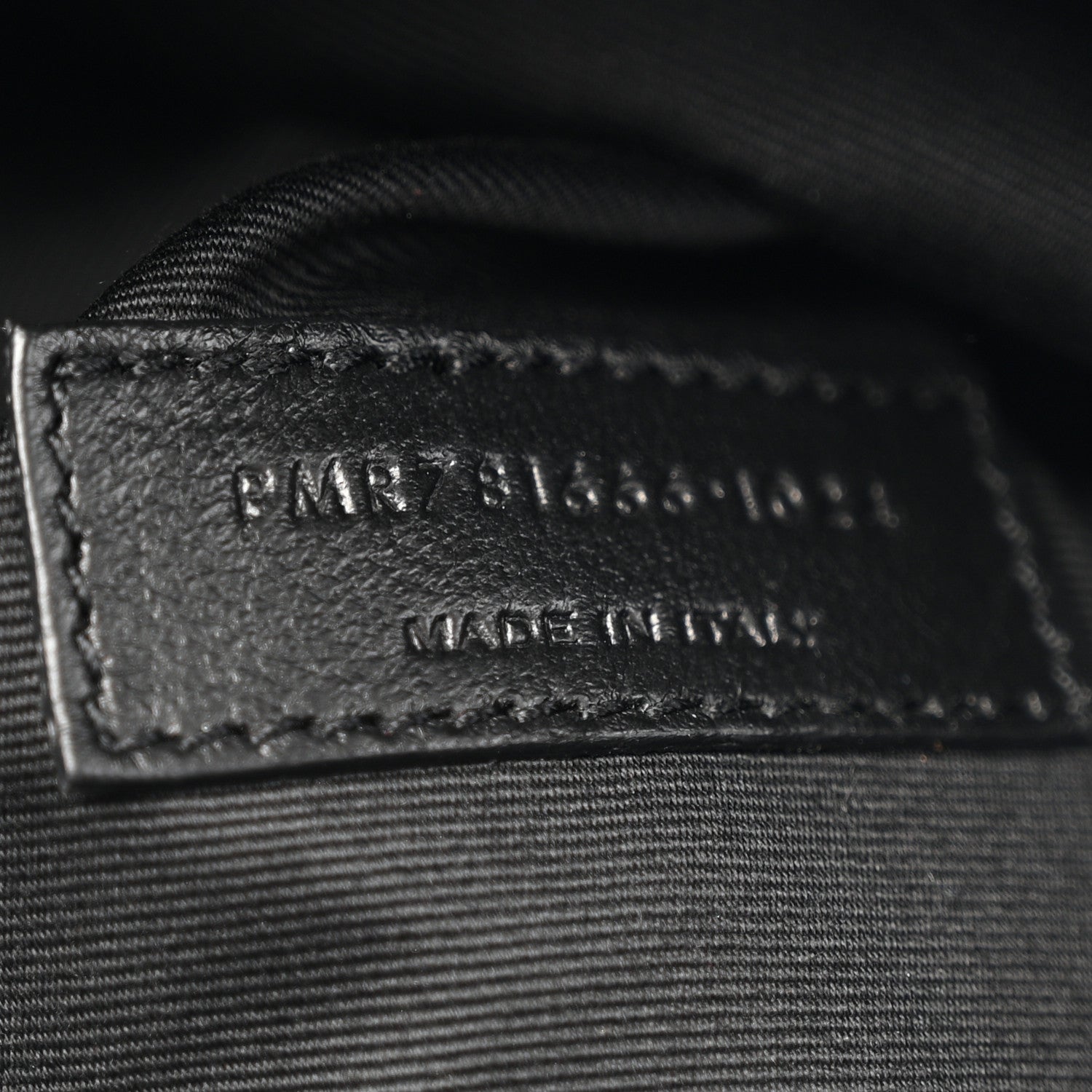 Black leather label with embossed branding and serial text on inner panel