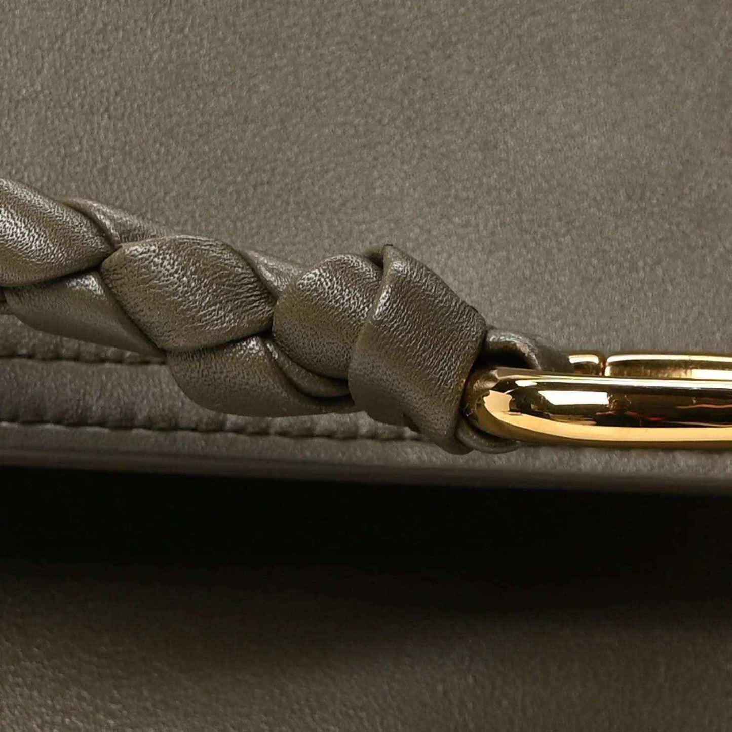 Braided leather strap detail with gold clasp hardware on cypress handbag