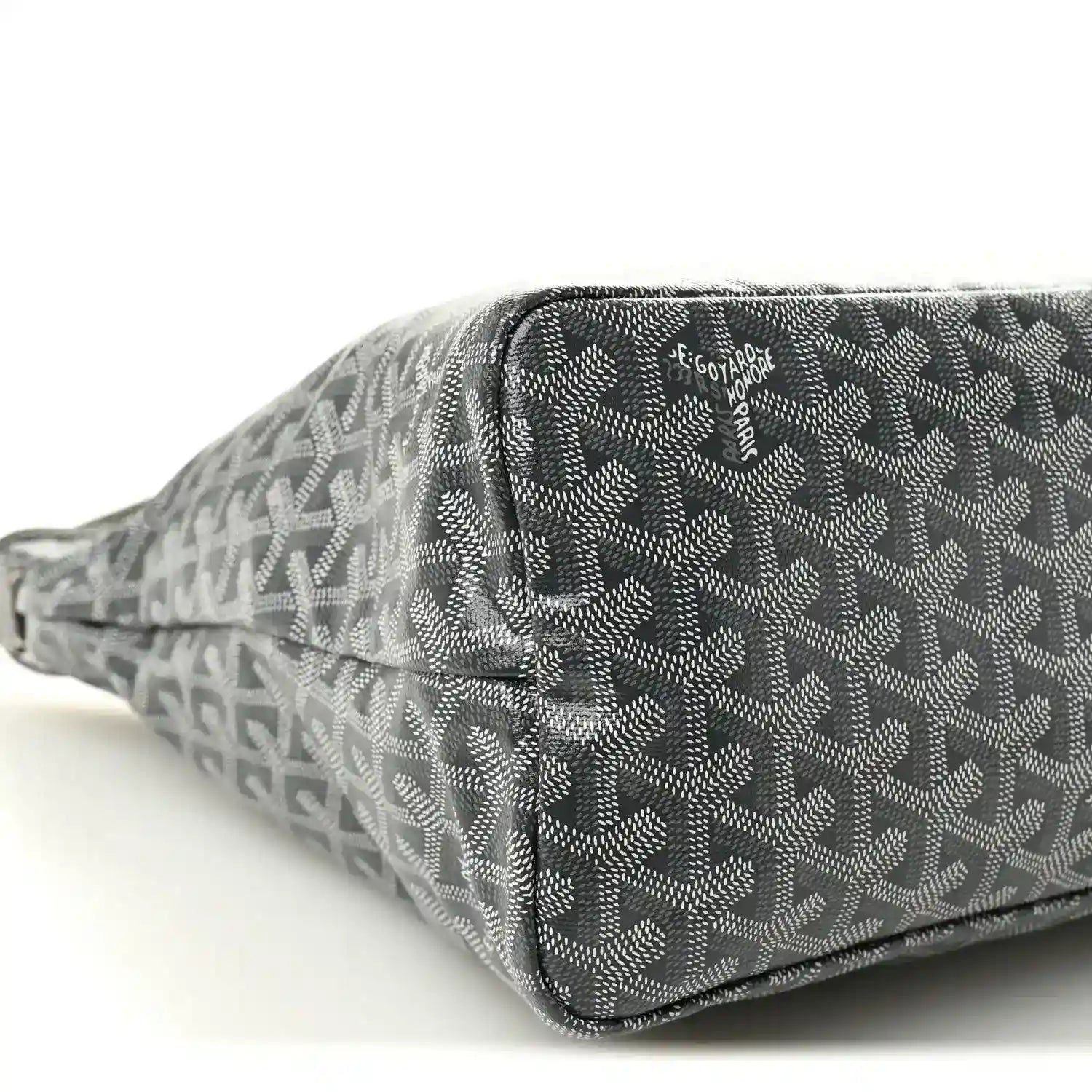 Grey canvas hobo bag close-up with zip edge, repeating pattern and logo patch