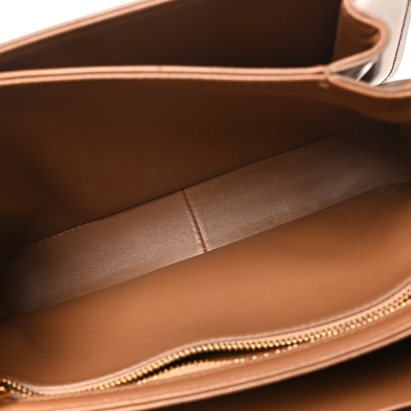 Bronze leather bag interior with stitched lining and gold-tone zipper opening