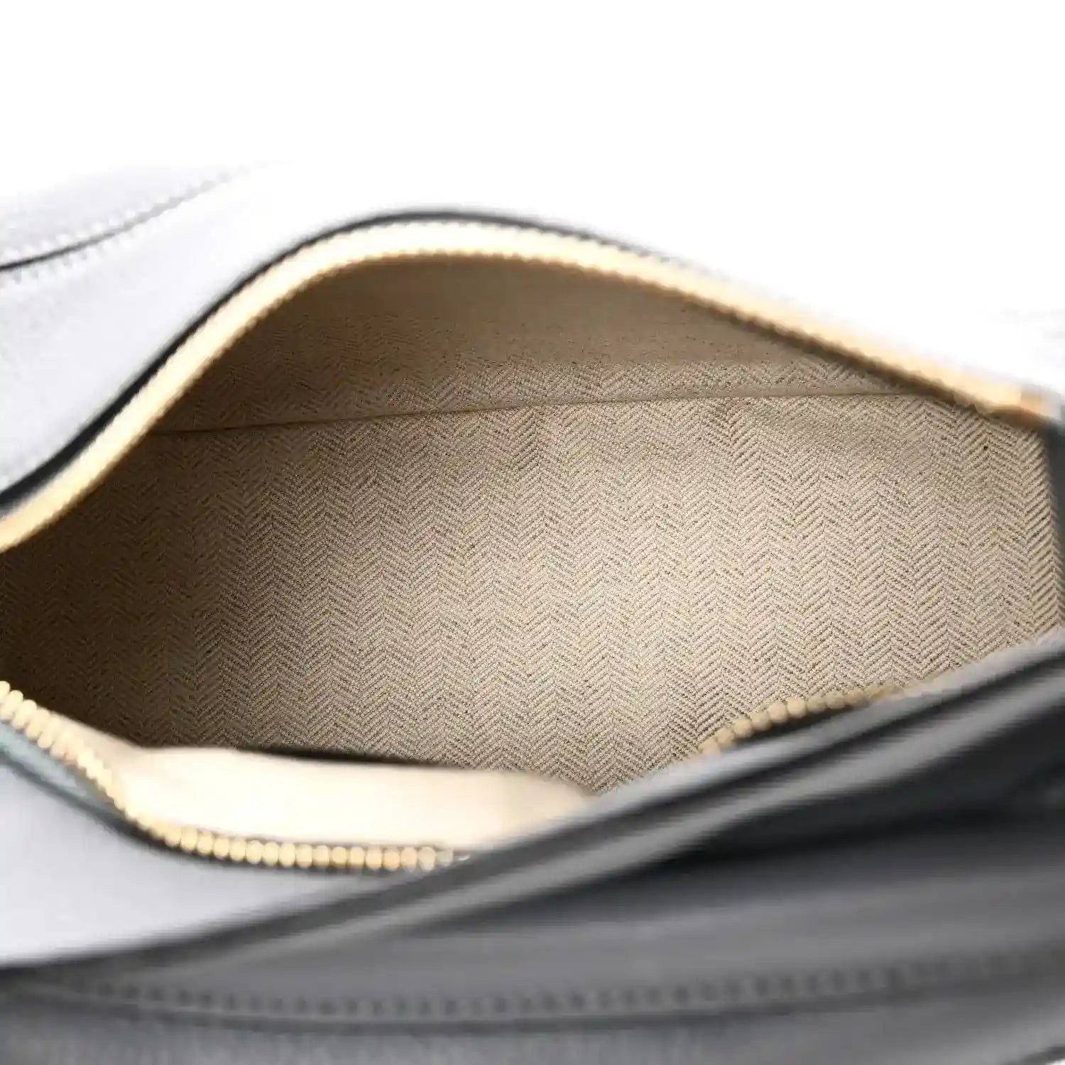 Small puzzle bag interior with light patterned fabric lining and top zipper opening edge