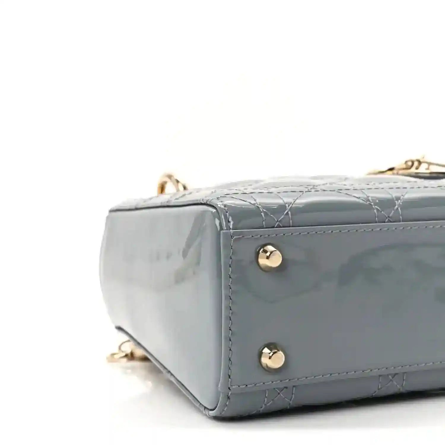 Light blue patent mini Lady Dior bag side view with gold studs and stitched seams