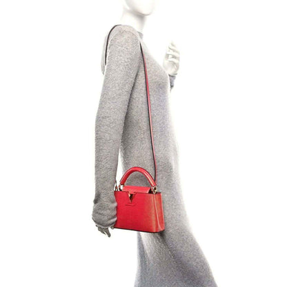 Louis Vuitton mini handbag, fuchsia textured lizard, crossbody strap, gold hardware.