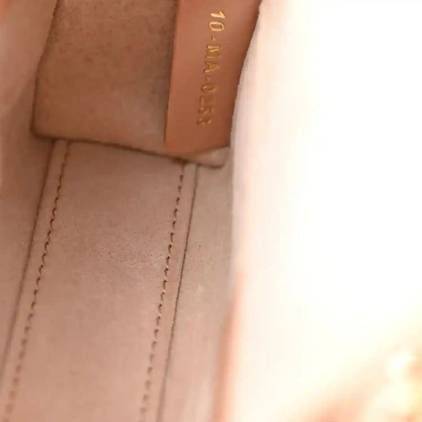 Pink beige leather panel and stitching inside micro handbag with embossed brand detail