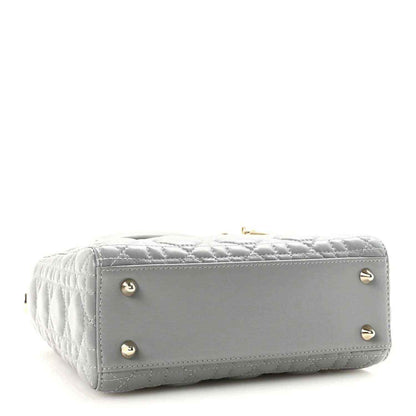 Grey quilted Lady Dior handbag with gold studs on the structured bottom
