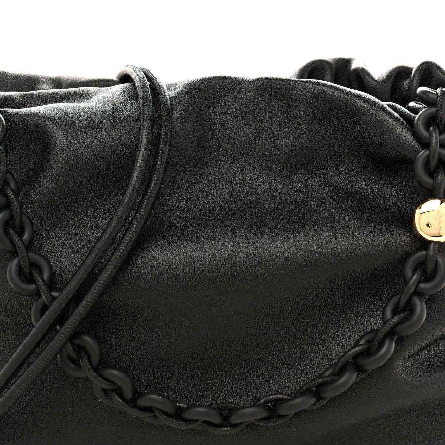 Black leather flamenco bag close-up with chain detail across the front
