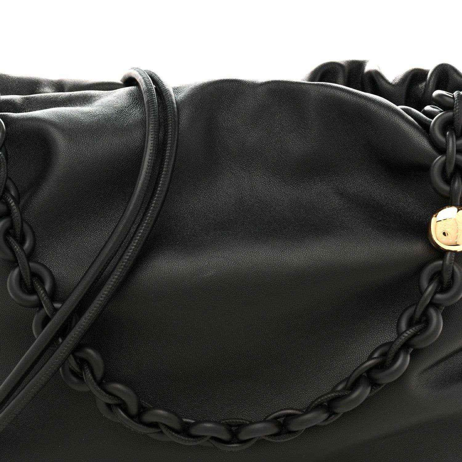 Black leather flamenco bag close-up with chain detail across the front