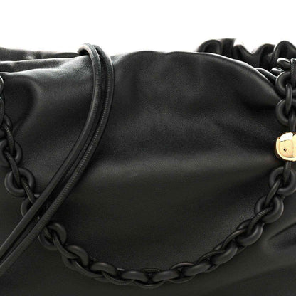 Black leather flamenco bag close-up with chain detail across the front
