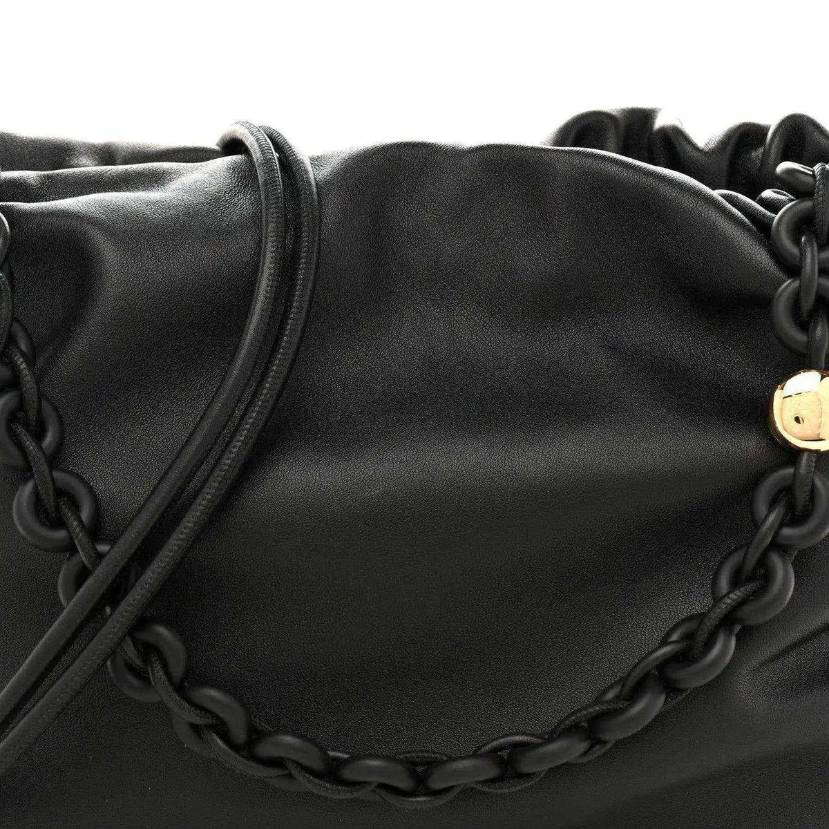 Black leather flamenco bag close-up with chain detail across the front