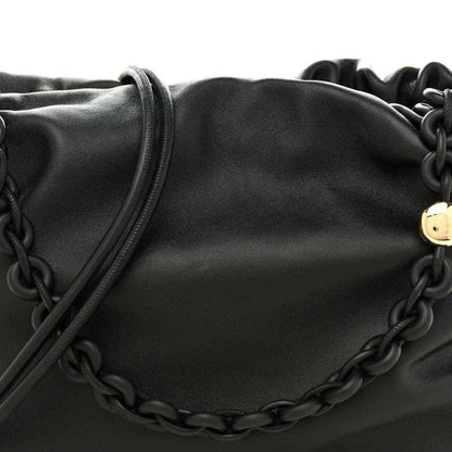 Black leather flamenco bag close-up with chain detail across the front