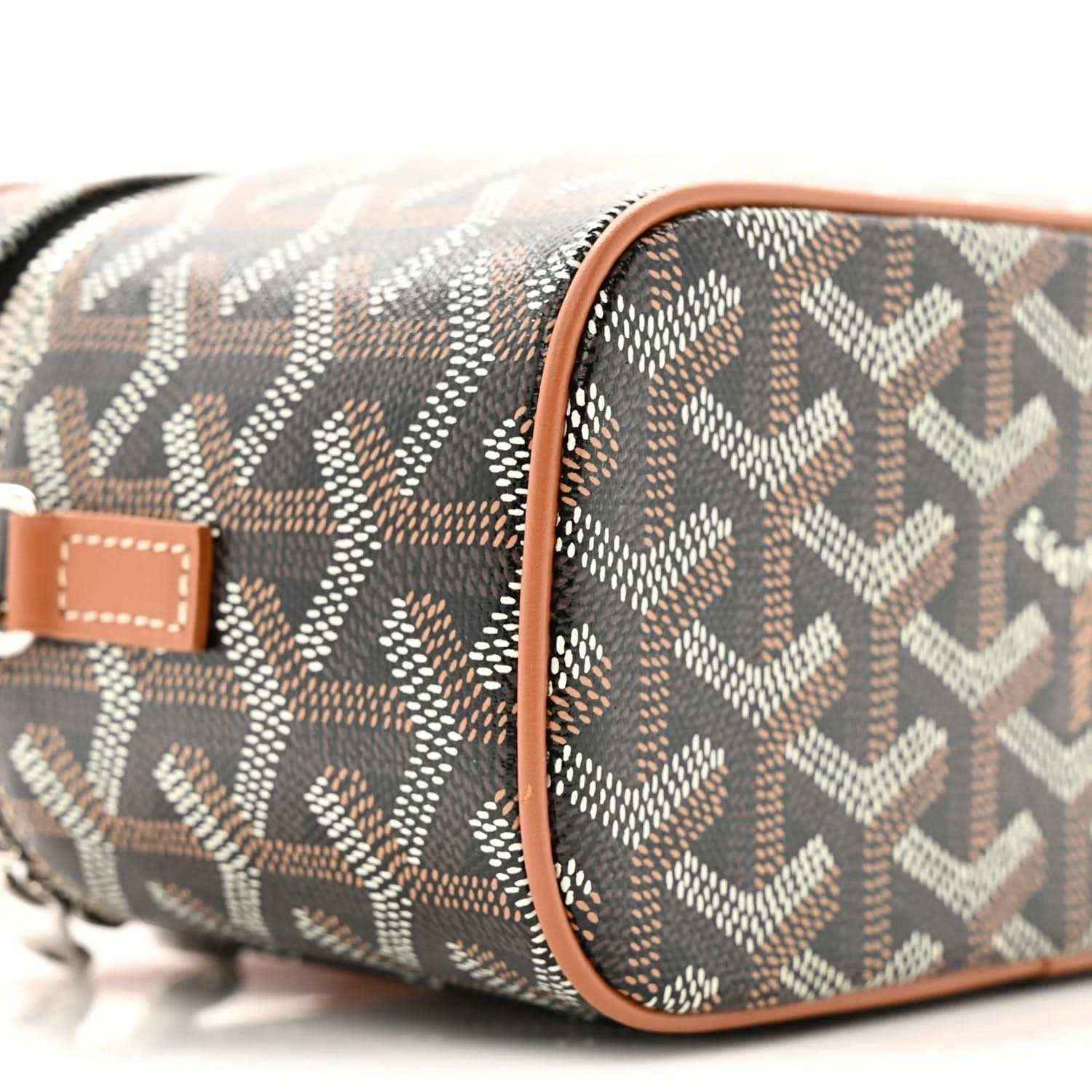 Mini vanity case side view; dark monogram canvas with tan leather corner trim