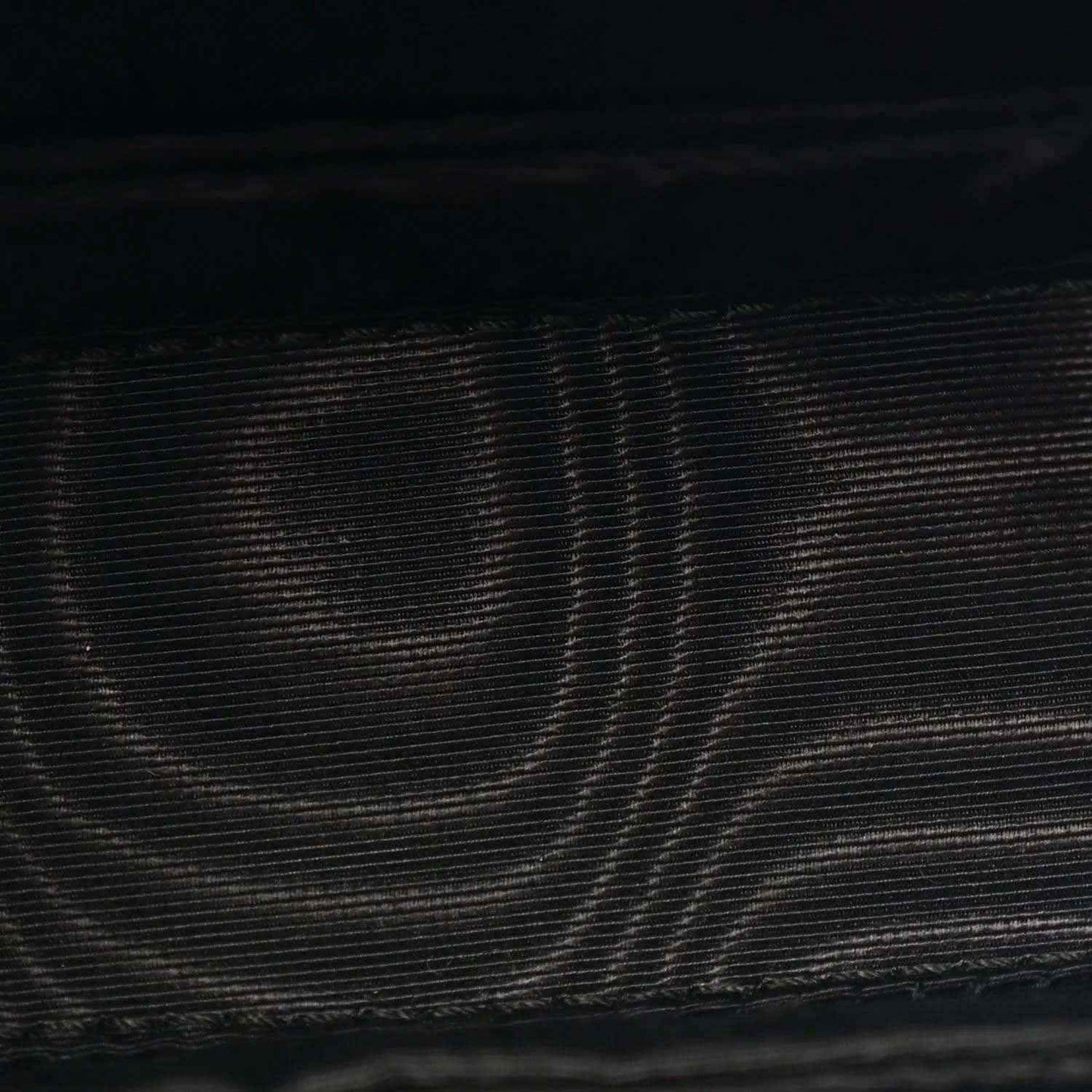 Close-up of black textured leather on mini bag exterior